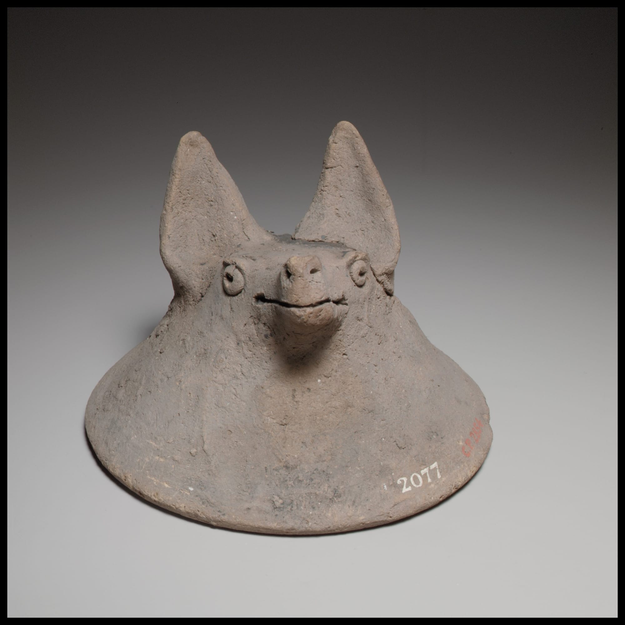 Photograph of a 7th century BCE work of pottery: Terracotta mask in the shape of the head of a fox, dog, or bat