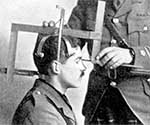 black and white photo of white man having head meassured with large device