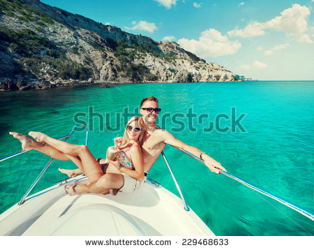 Cheerful skinny white heterosexual couple in bathing suits on luxury boat